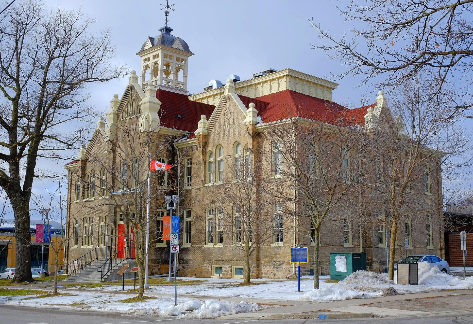 The historic Church Street School building in Aurora, with its red roof and tower, in winter